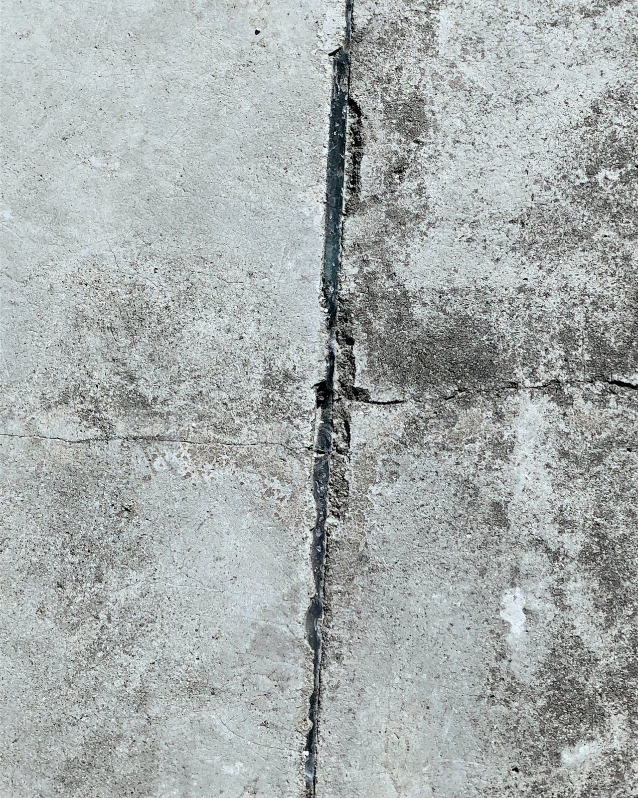 A sealed crack running through a concrete surface